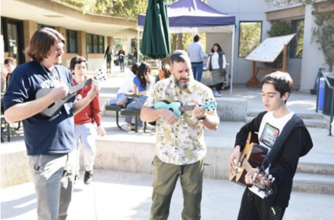 Mr. Lindsay, Rabbi David, and Zev Gaslin share music with their peers on the guitar and ukulele during 2.0neg.