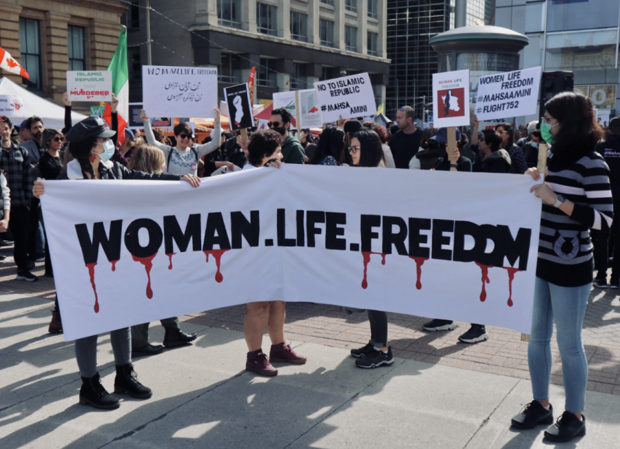 Protestors holding the official slogan of the movement, Woman, Life, Freedom (Taymaz Valley/CC BY 2.0)