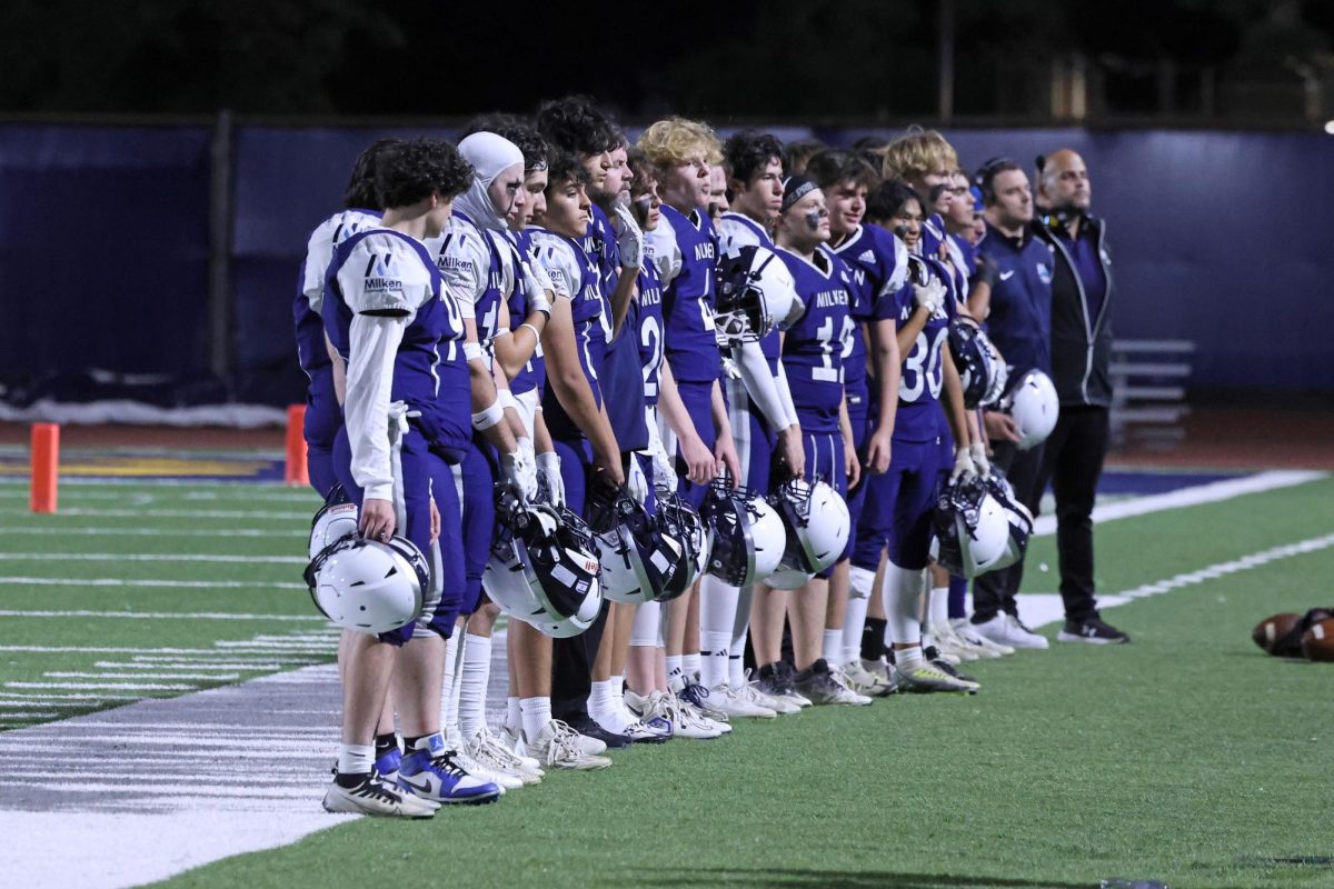 Milken football team and coaches line up for the American and Israeli national anthems at a Milken home game.