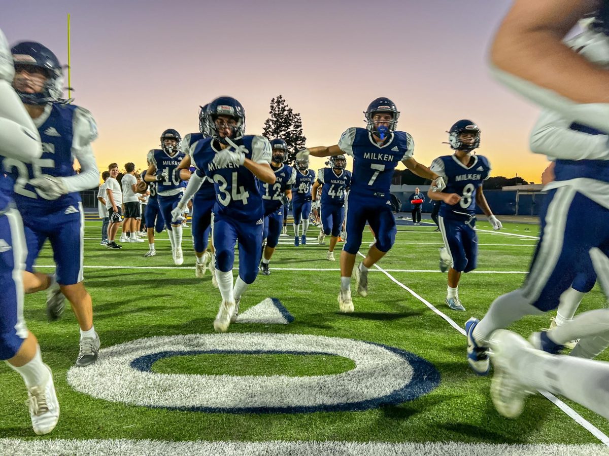 Milken's Football Team charges the field to start the game on Homecoming Night 