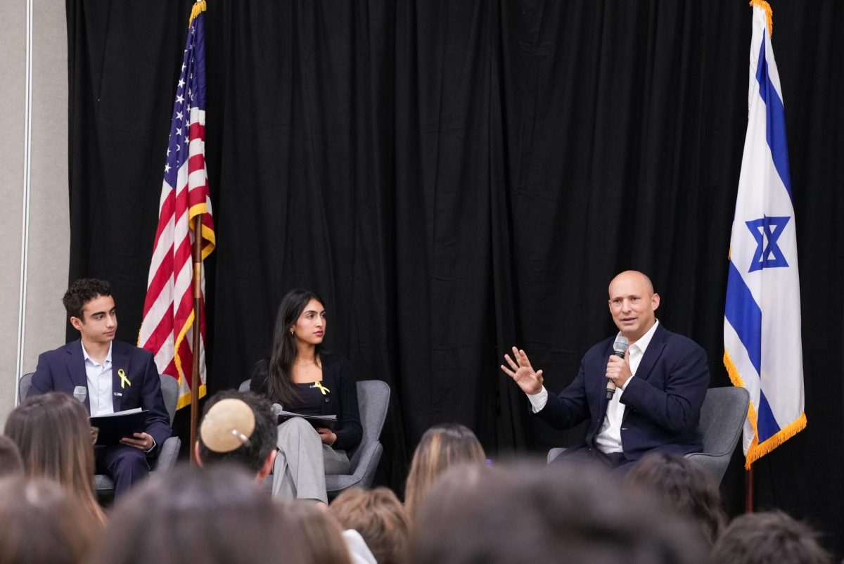 Tomer Z ‘26 (left) and Noa F ‘25 (right) listen to Naftali Bennett as he speaks on the current Israeli-Palestinian conflict.